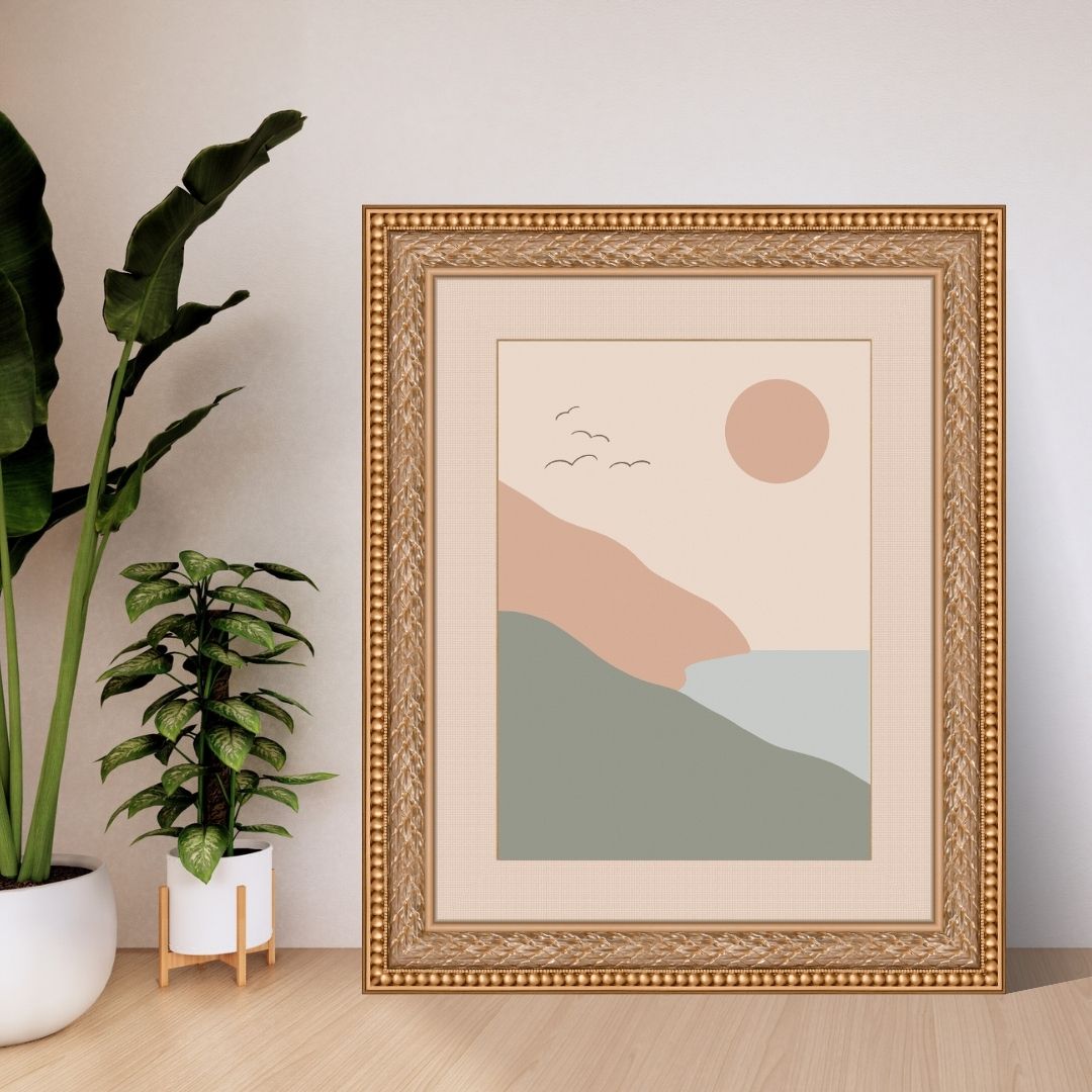 Framed abstract landscape art on a wall with plants in the background
