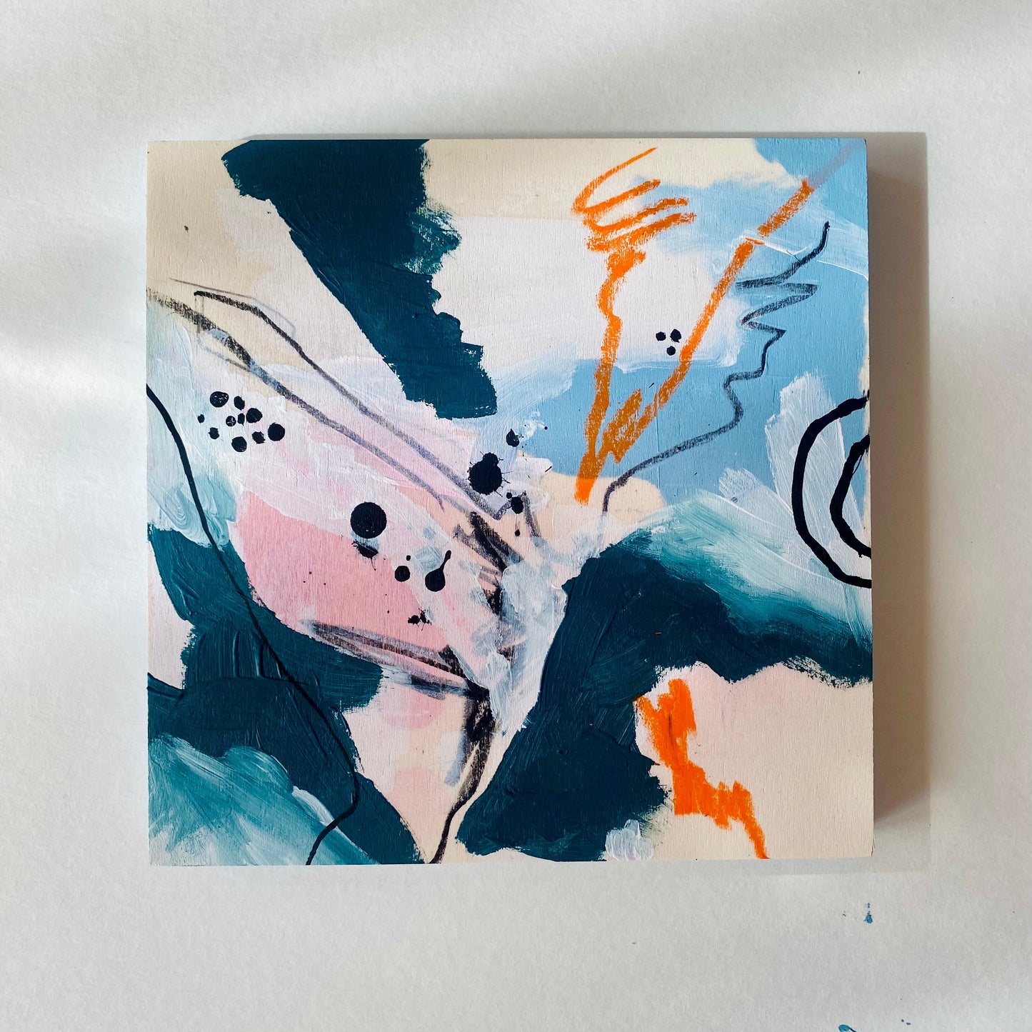 Abstract painting with blue, pink, and orange on a white background