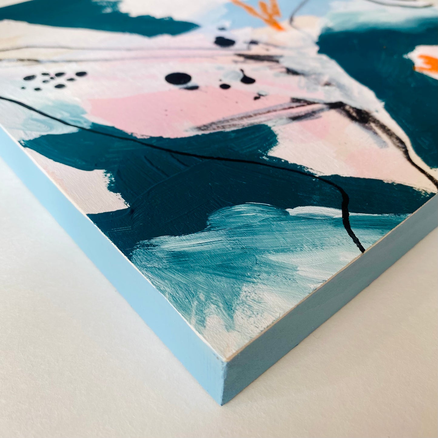 Close-up of a painting with abstract design on a light blue background