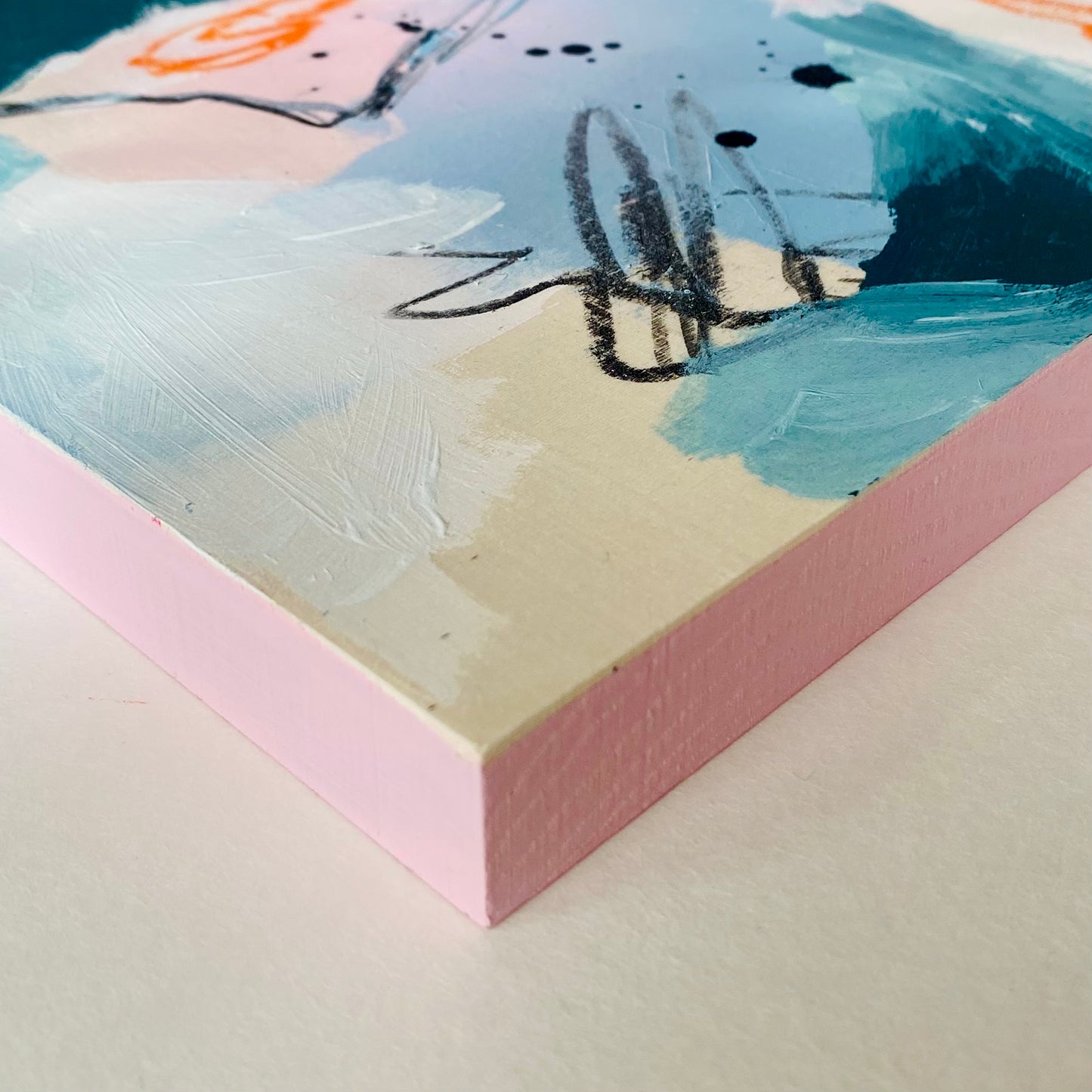 Close-up of a textured painting with abstract brushstrokes on a pink background