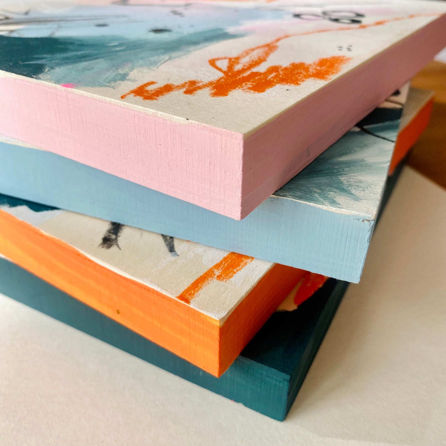 Stack of colorful books with abstract designs on a light surface